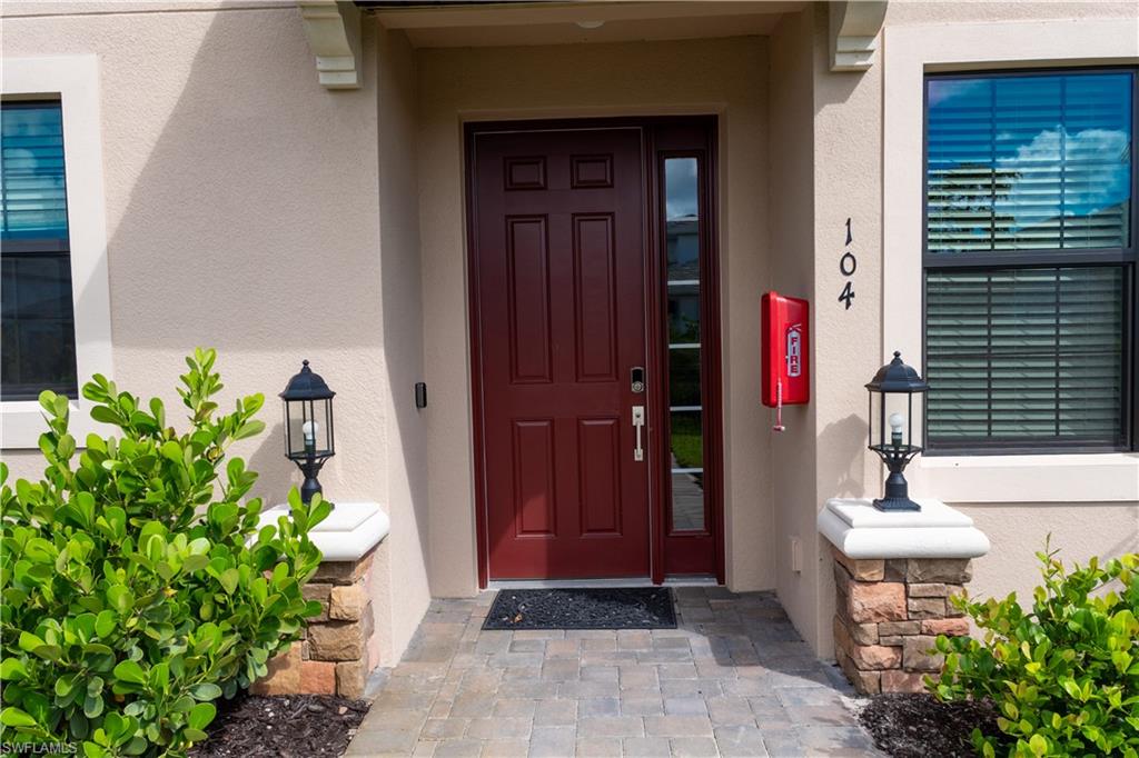 15335 Lucerna Street, Unit 104 Naples, FL 34114 - Photo 7 of 44 a front view of a house with a garage
