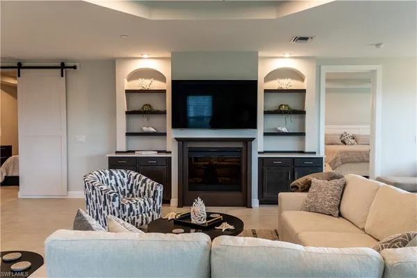 a living room with furniture a fireplace and a flat screen tv