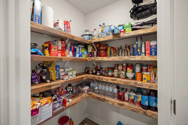 a kitchen with stainless steel appliances kitchen island granite countertop a stove a sink dishwasher and a dining table with white cabinets