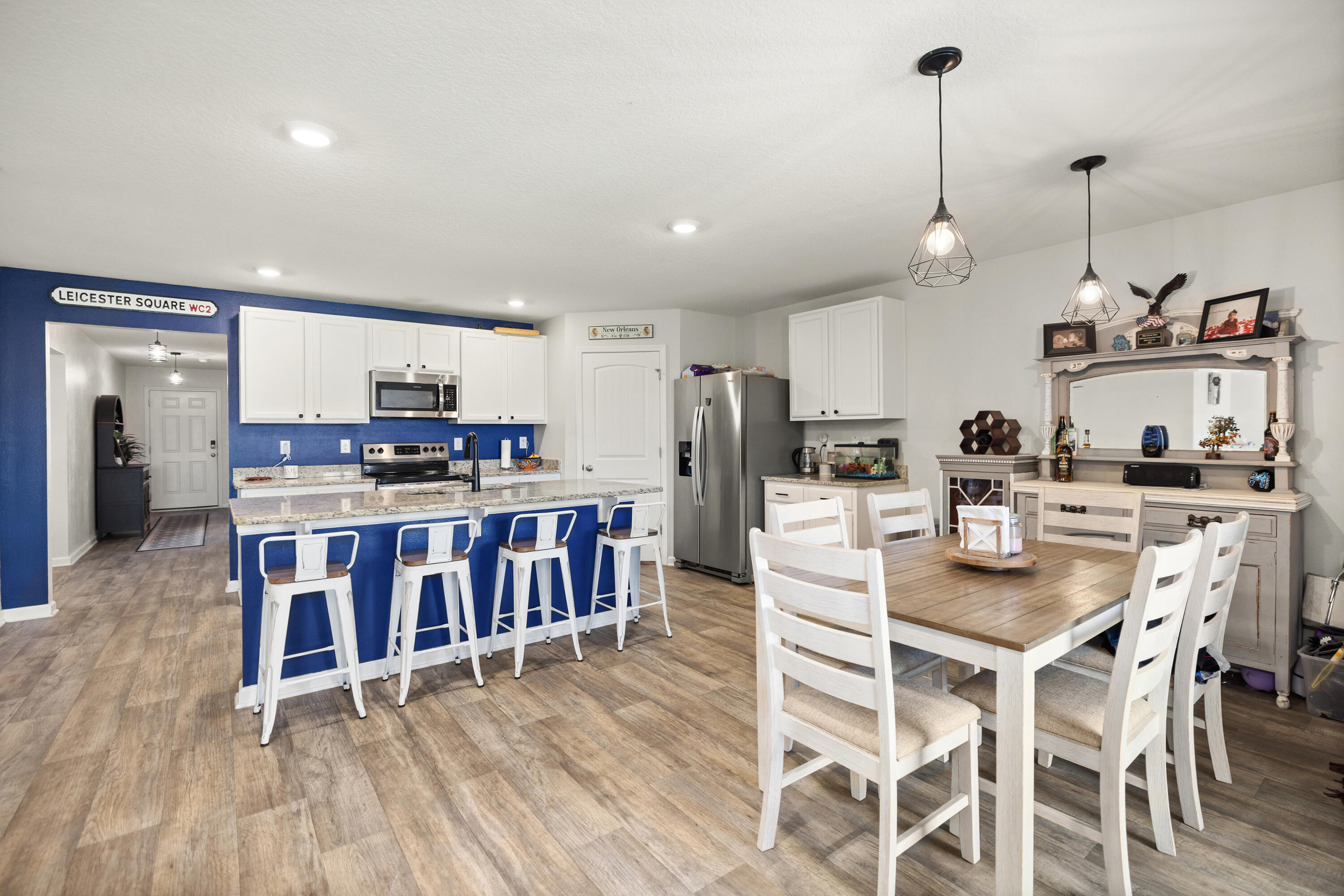 1016 Limpkin Street Crestview, FL 32539 - Photo 25 of 60 a kitchen with stainless steel appliances kitchen island granite countertop a stove a sink dishwasher and a dining table with white cabinets