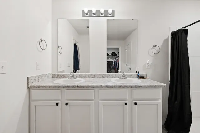 a bedroom with a bed and a flat tv screen on dresser