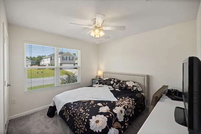 a bedroom with a bed and a flat tv screen on the dresser