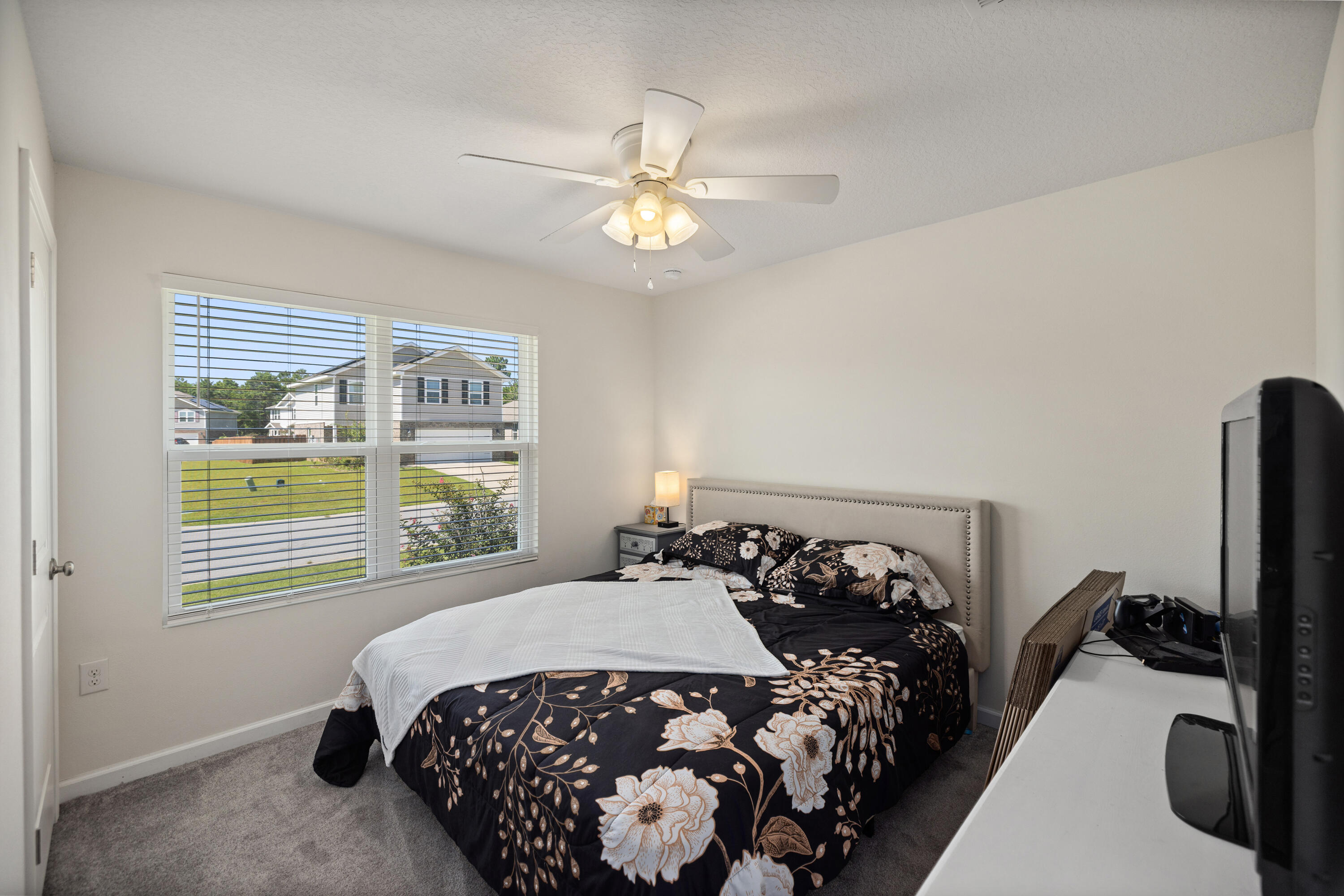 1016 Limpkin Street Crestview, FL 32539 - Photo 36 of 60 a bedroom with a bed and a chandelier