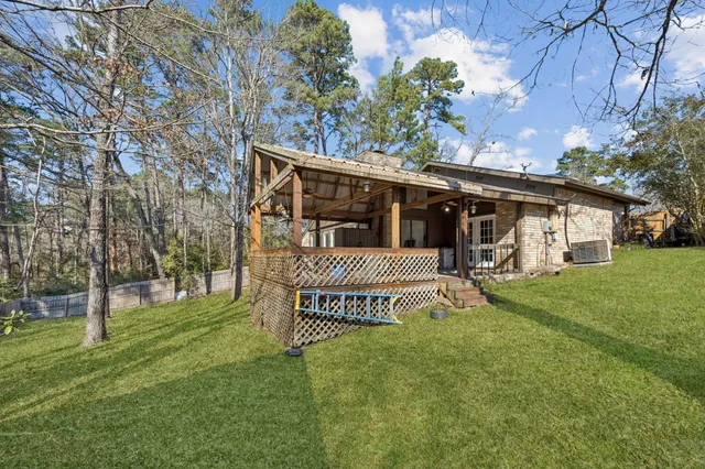 a view of a house with a big yard and large tree