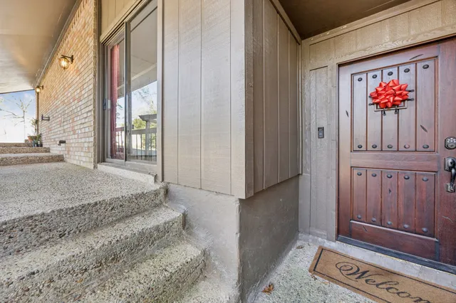a view of a hallway with wooden floor and windows