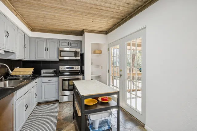 a kitchen with stainless steel appliances granite countertop a stove sink and cabinets