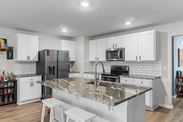 a kitchen with stainless steel appliances granite countertop a stove oven and a refrigerator