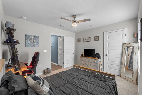 a bedroom with a bed and a ceiling fan