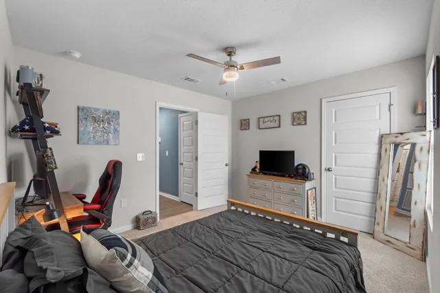 a bedroom with a bed and a ceiling fan