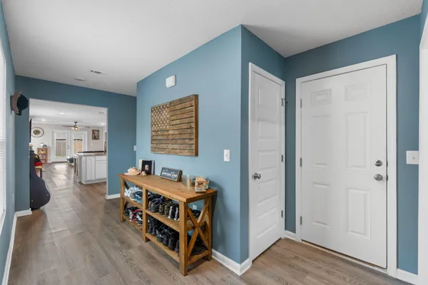 a view of a hallway with wooden floor and furniture