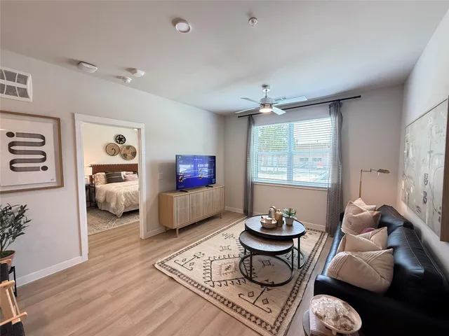 a living room with furniture a rug and a window