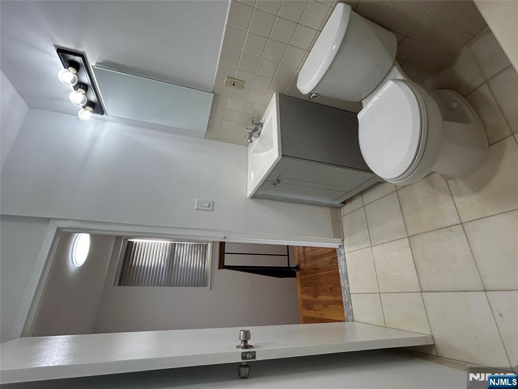109 Grand Avenue, Unit 1A Englewood, NJ 07631 - Photo 21 of 25 a white toilet sitting next to a bathroom sink