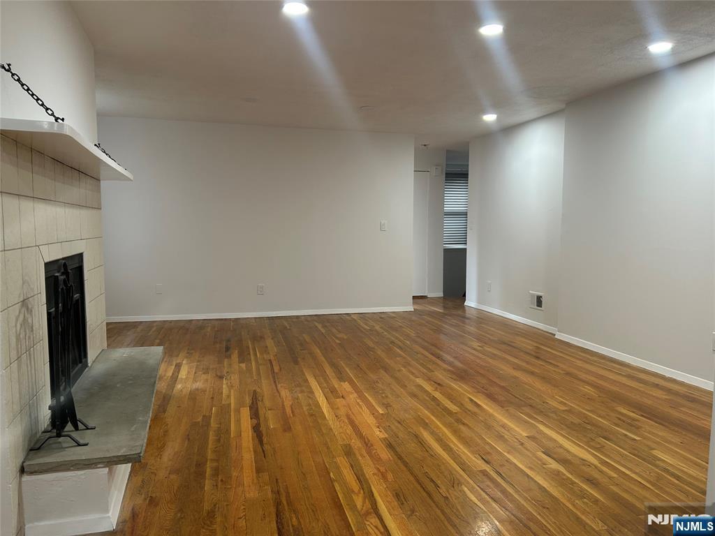109 Grand Avenue, Unit 1A Englewood, NJ 07631 - Photo 4 of 25 a view of a room with wooden floor and a fireplace