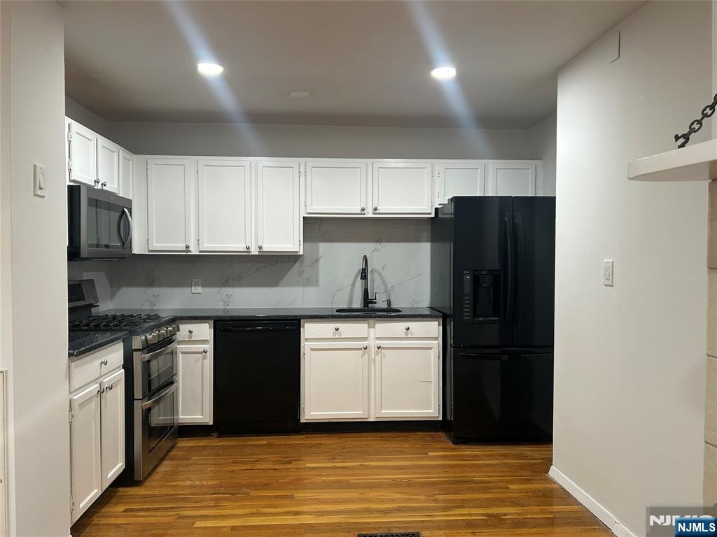 109 Grand Avenue, Unit 1A Englewood, NJ 07631 - Photo 5 of 25 a kitchen with a sink and a refrigerator
