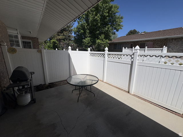 486 West 120 North Orem, UT 84057 - Photo 24 of 30 Private concrete patio featuring white vinyl fencing with decorative lattice accents and a covered overhang