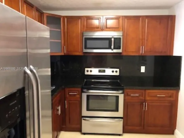 a kitchen with stainless steel appliances wooden cabinets and a stove top oven