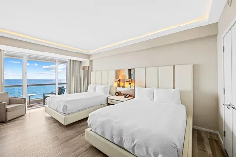 a bedroom with two beds and large window