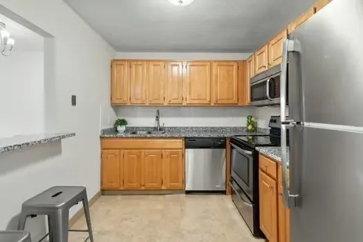 a kitchen with stainless steel appliances granite countertop a stove a sink and a microwave