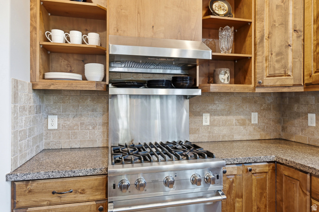 3148 Lower Saddleback Road Park City, UT 84098 - Photo 18 of 67 Gourmet kitchen featuring a stainless steel gas range, coordinating range hood, granite countertops, and a stone tile backsplash