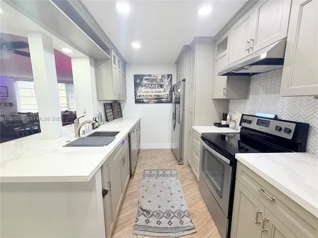 a kitchen with stainless steel appliances a sink stove and cabinets
