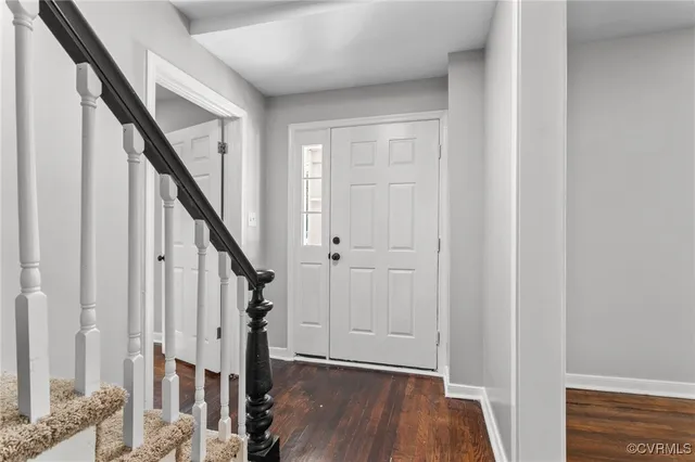 a view of staircase with wooden floor and white walls