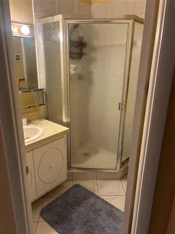 a bathroom with a granite countertop shower and a sink