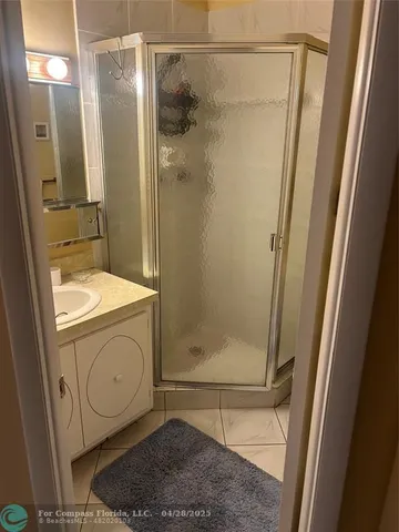a bathroom with a granite countertop shower and a sink