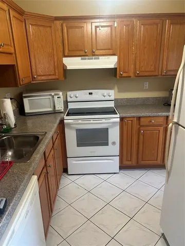 a kitchen with a sink a stove and cabinets