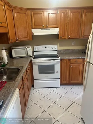 a kitchen with a sink a stove and cabinets