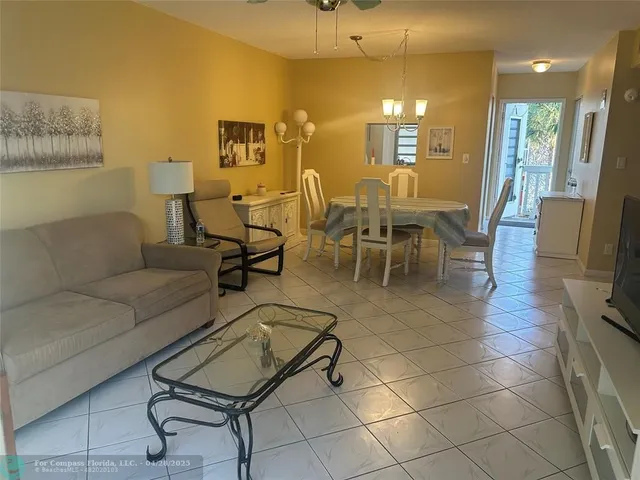a living room with furniture a dining table and a mirror