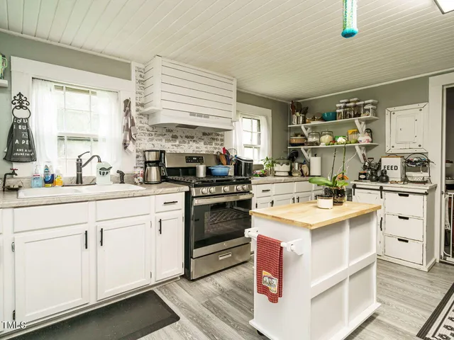 a kitchen with a stove sink and cabinets