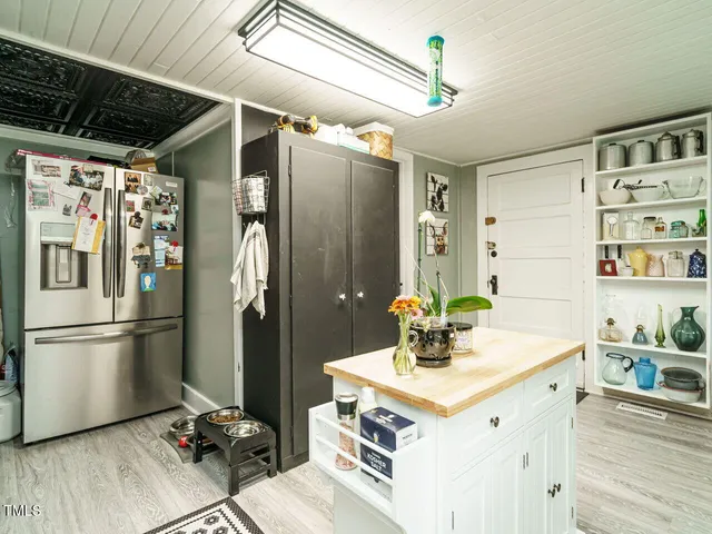 a kitchen with stainless steel appliances kitchen island granite countertop a refrigerator and a sink