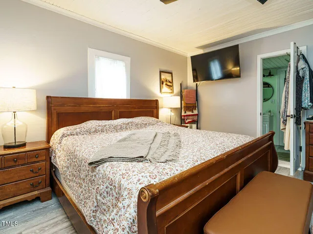 a bedroom with a bed and a flat screen tv