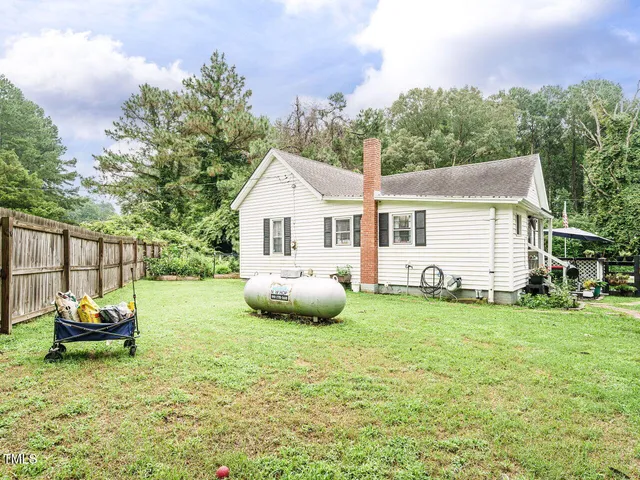 a backyard of a house with table and chairs