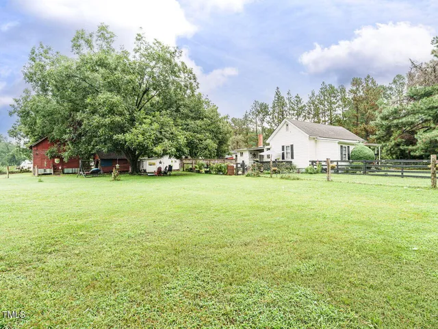 a view of a house with yard and green space