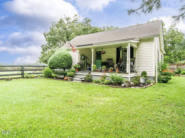 a view of a house with backyard sitting area and garden
