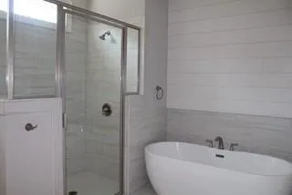 a bathroom with a white bath tub and a shower