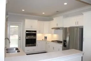 a kitchen with stainless steel appliances kitchen island granite countertop a refrigerator and a sink