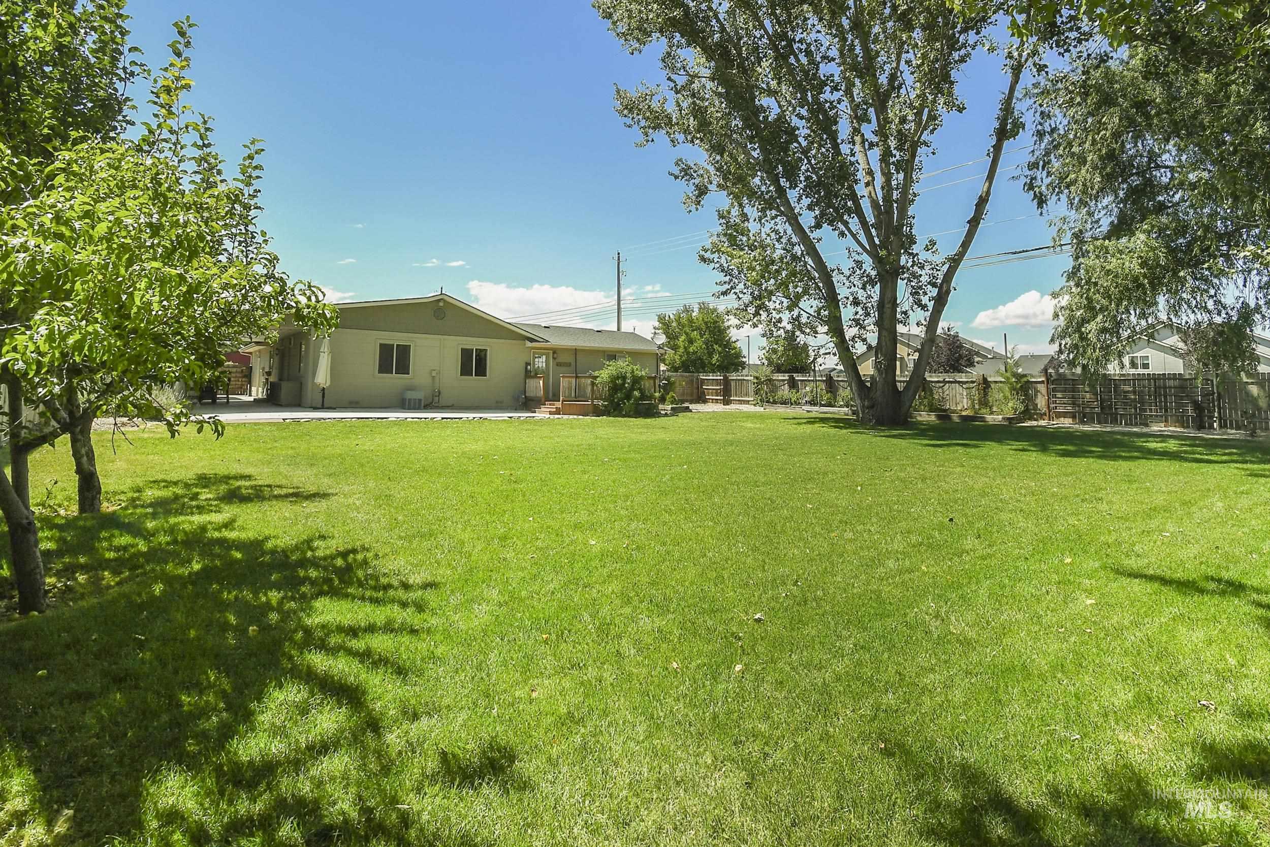 1108 East Ustick Road Caldwell, ID 83607 - Photo 30 of 30 Expansive green lawn with mature trees and a fenced perimeter