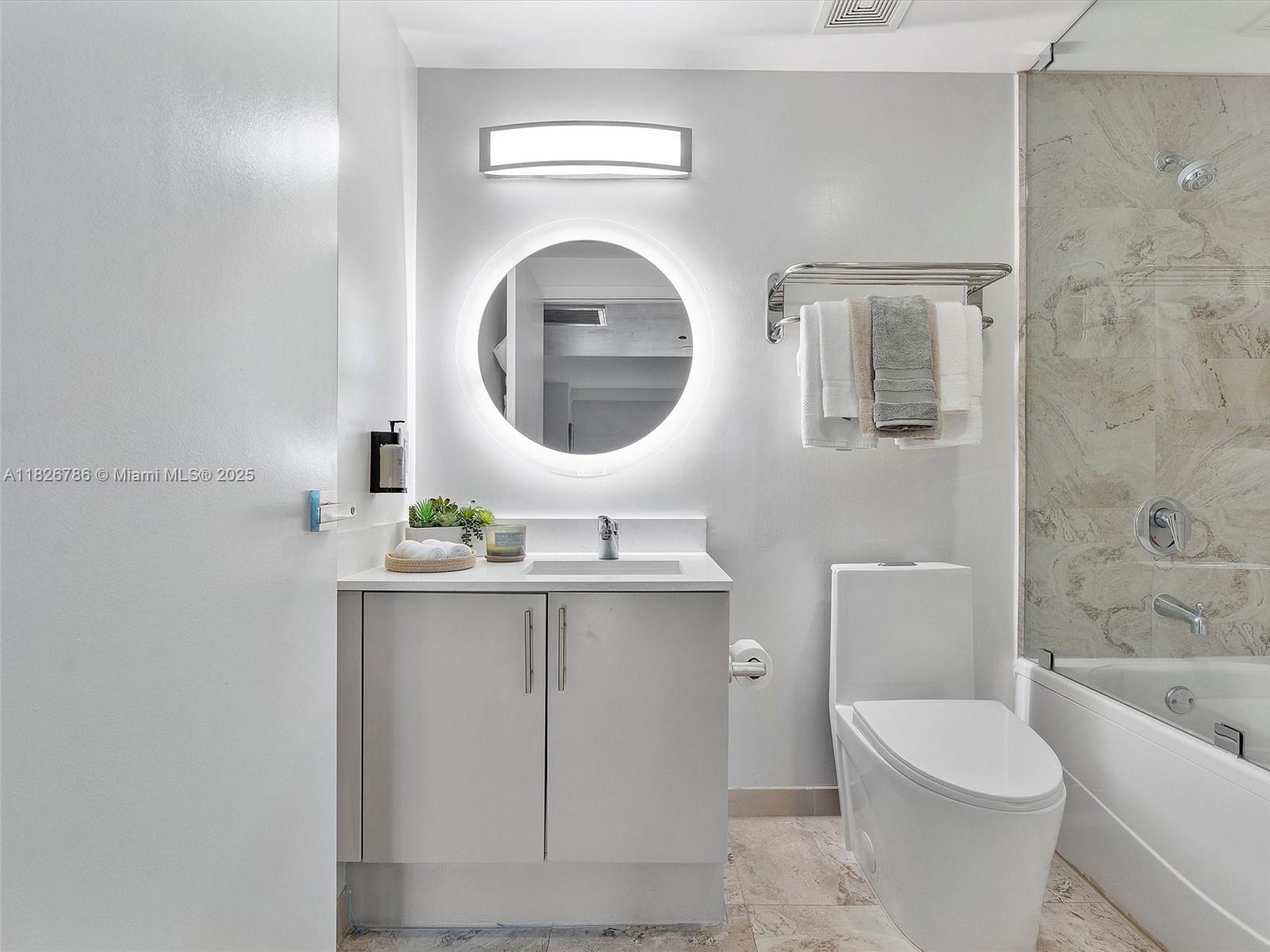 2889 McFarlane Road, Unit 1908 Miami, FL 33133 - Photo 26 of 26 a bathroom with a toilet a sink and mirror