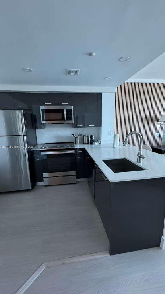 2889 McFarlane Road, Unit 1908 Miami, FL 33133 - Photo 9 of 26 a kitchen with stainless steel appliances granite countertop a sink and a stove