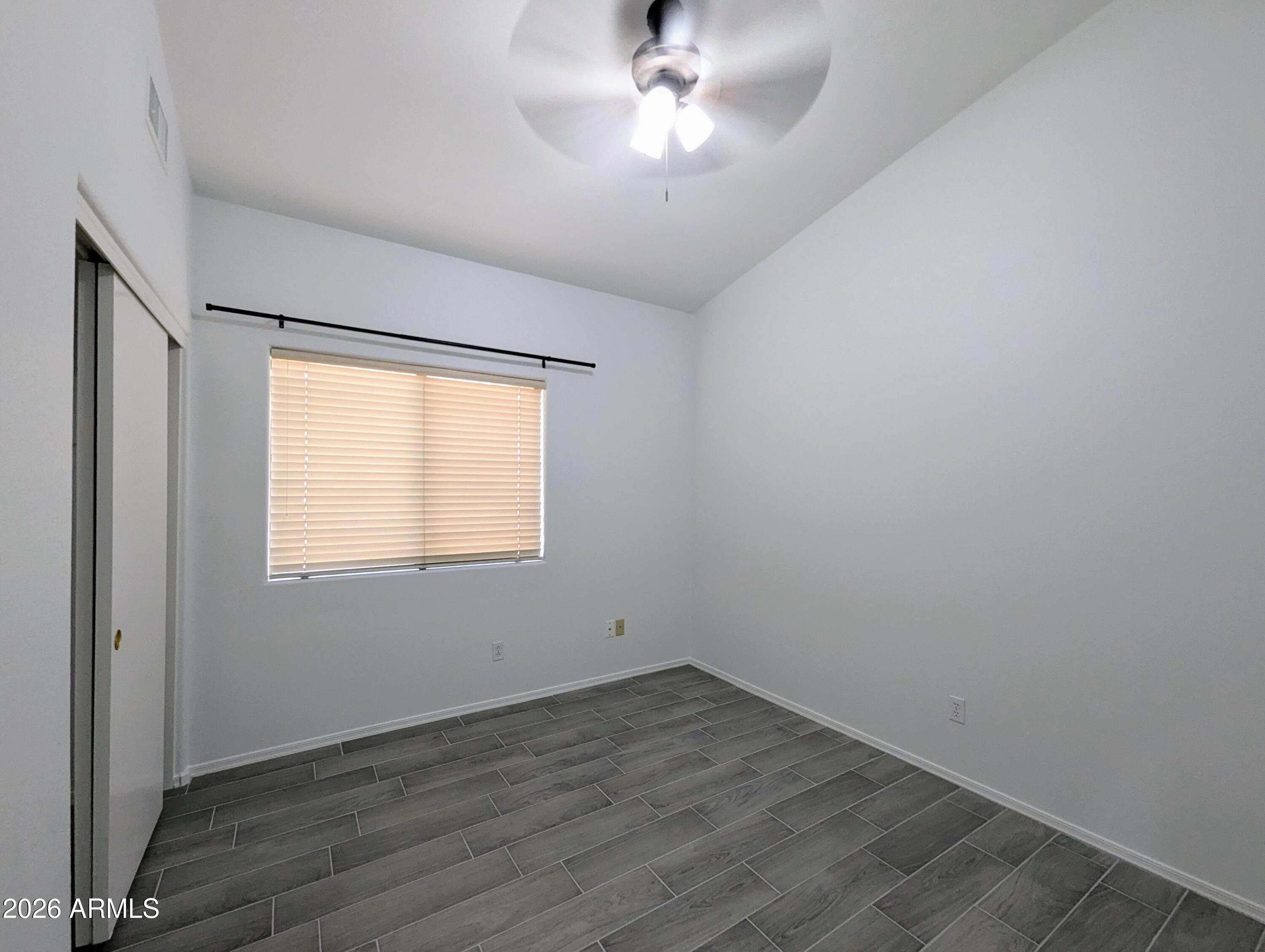 5424 West Wagoner Road Glendale, AZ 85308 - Photo 25 of 37 an empty room with wooden floor and windows