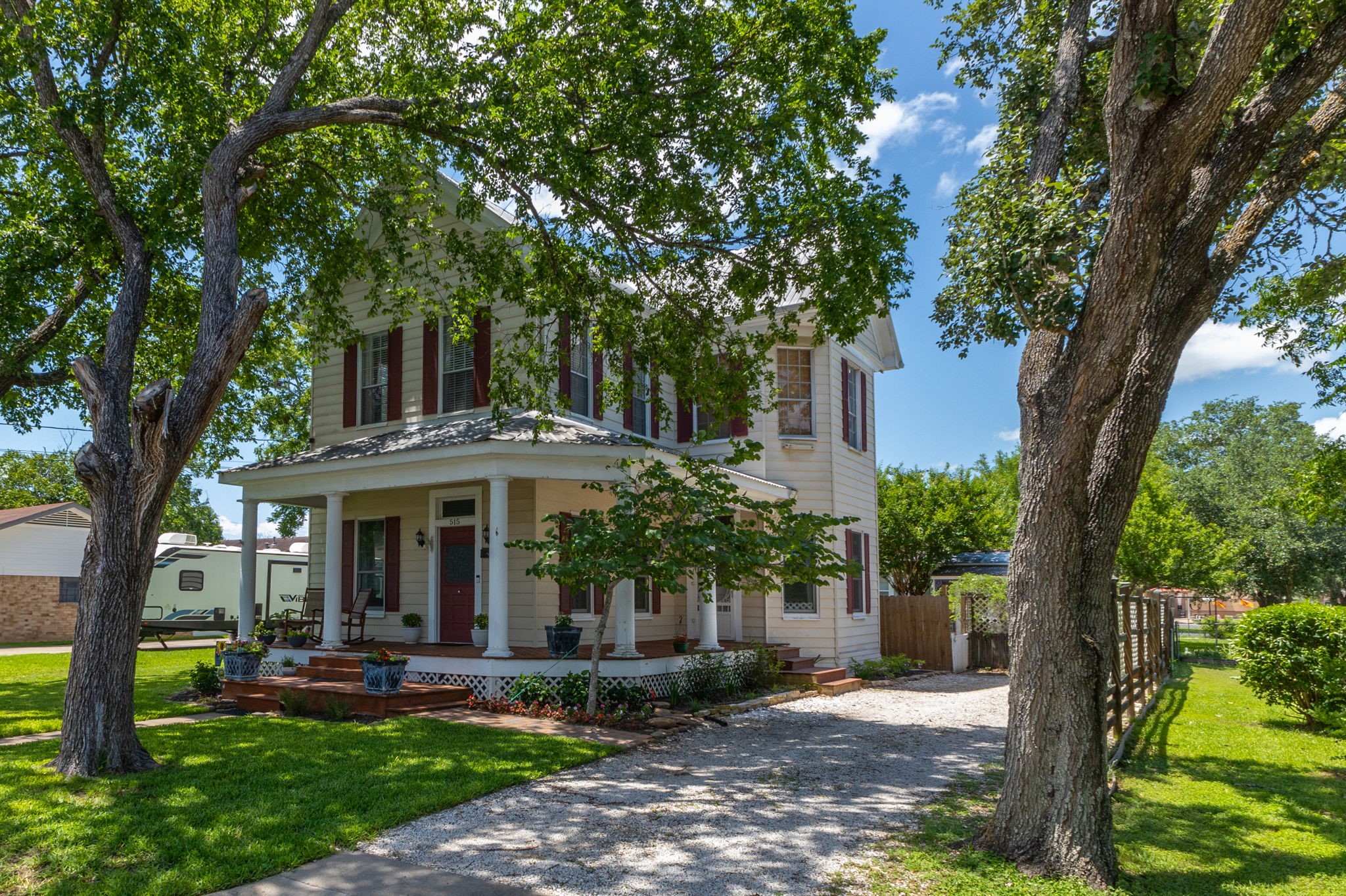 a view of a house with a yard and large tree