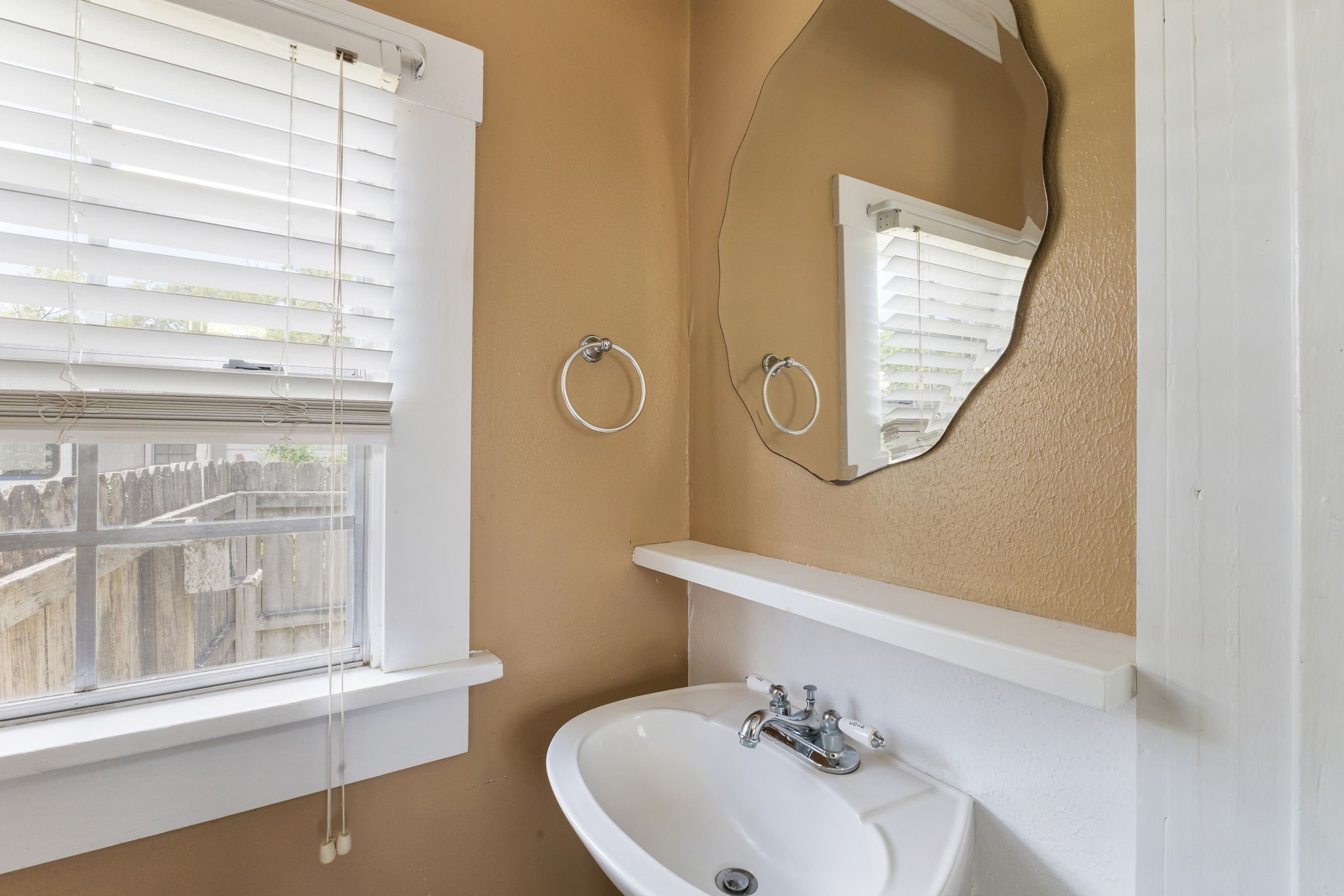 515 Wolf Street Schulenburg, TX 78956 - Photo 16 of 39 a bathroom with a sink a mirror and a window