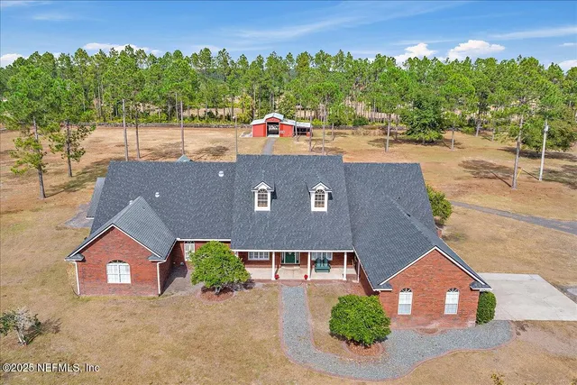 an aerial view of a house with swimming pool and a yard