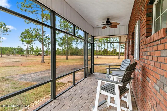 a dining room with wooden floor a chandelier a glass table and chairs