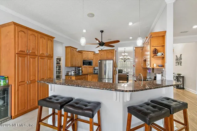 a kitchen with granite countertop a refrigerator stove top oven a sink and dishwasher