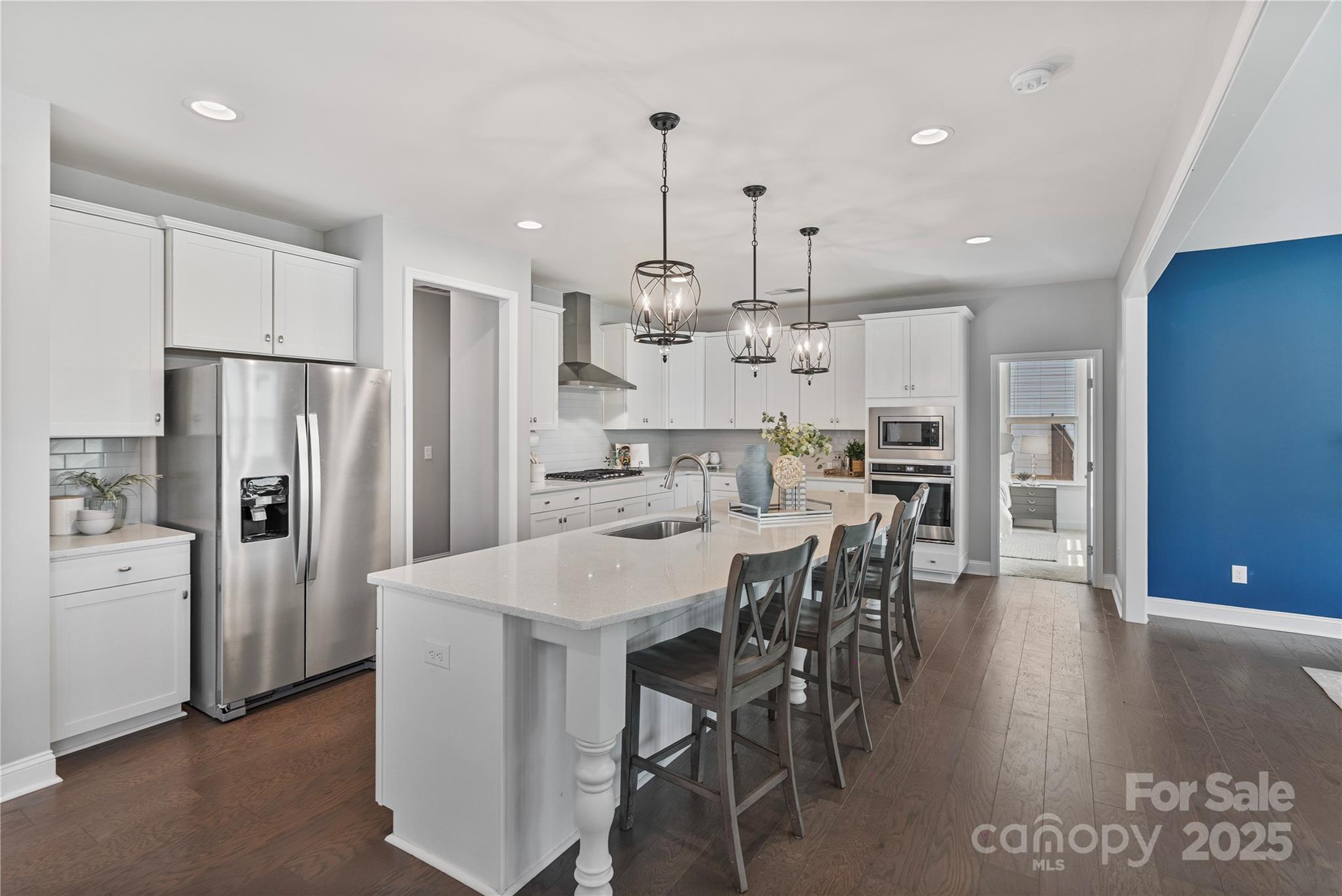 2225 Masons Bend Drive Fort Mill, SC 29708 - Photo 5 of 45 a kitchen with stainless steel appliances kitchen island a table chairs refrigerator and wooden floor