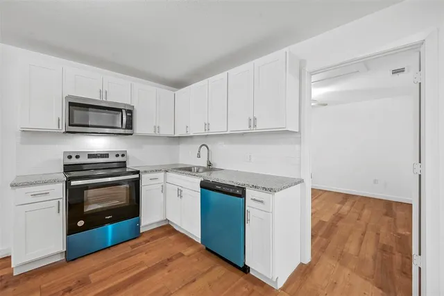 a kitchen with stainless steel appliances granite countertop a stove top oven a sink and dishwasher