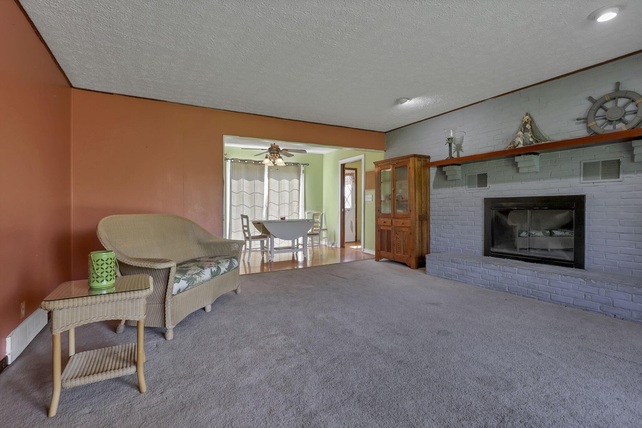 6605 Lancaster Road Hebron, OH 43025 - Photo 16 of 53 Spacious family room featuring a stunning brick fireplace and floor-to-ceiling windows that flood the space with natural sunlight.